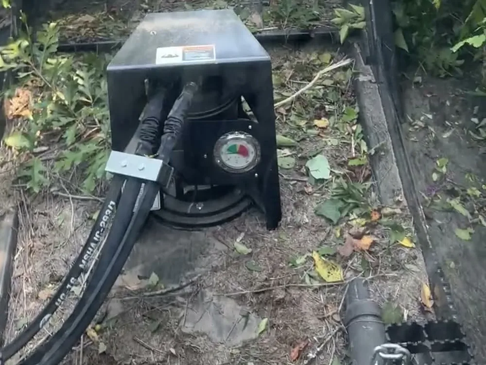 Mulching head on the track loader resting on freshly cleared ground covered in chips and leaves