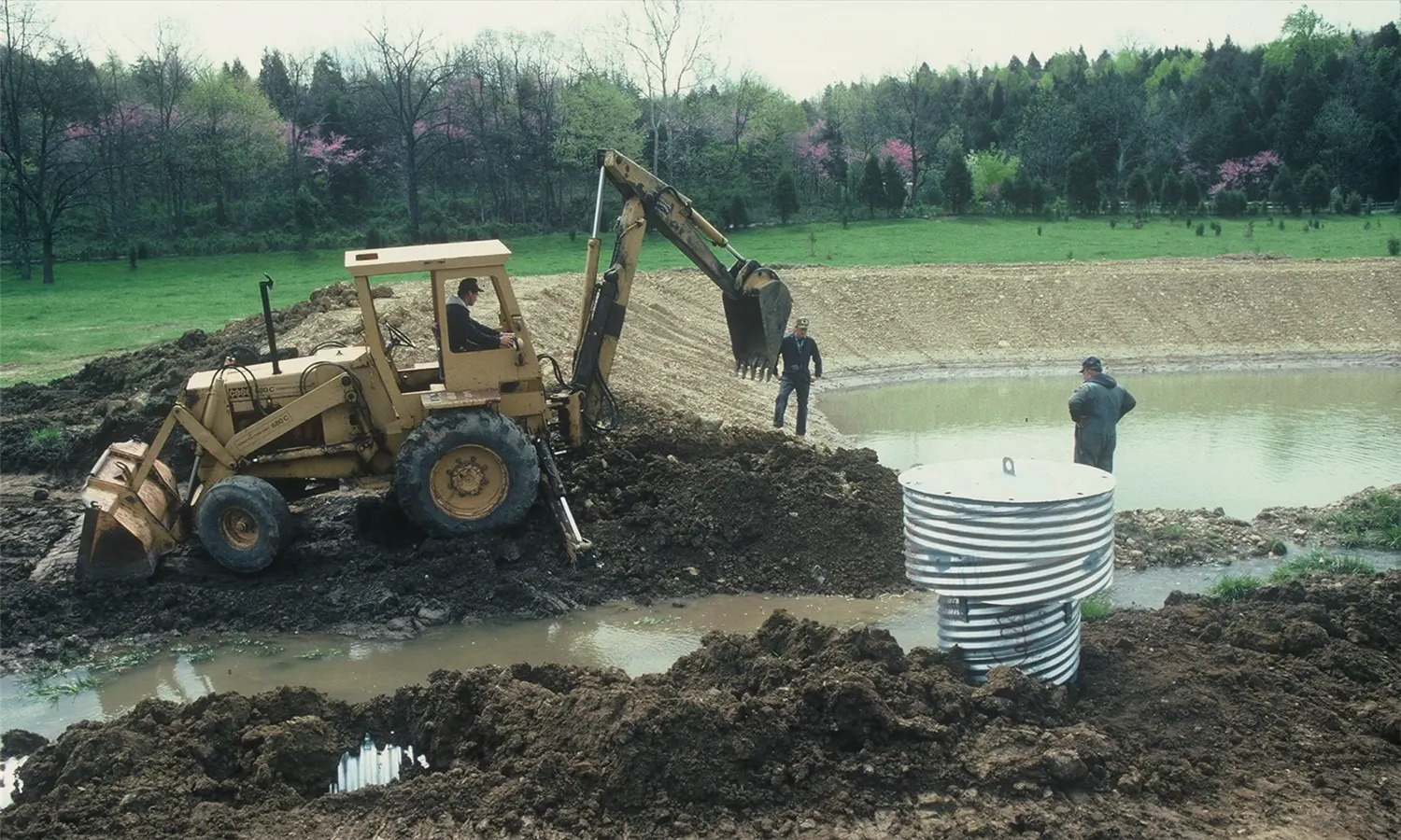 Excavator shaping a new pond on rural Northeast Louisiana land